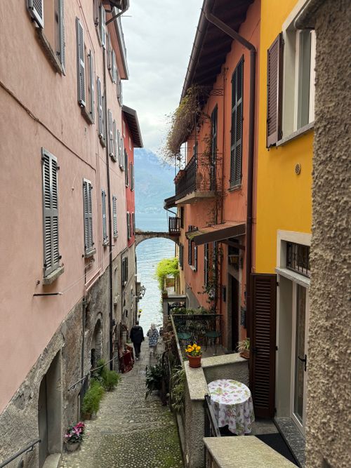 Free Charming alleyway view in Varenna, Italy, showcasing colorful buildings and lake backdrop. Stock Photo