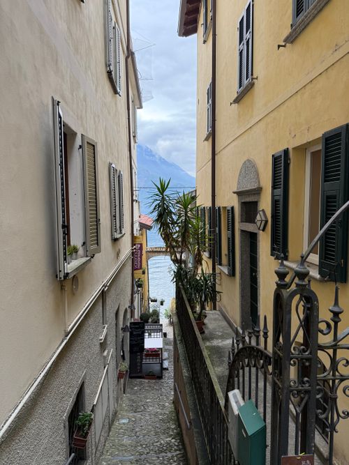 Free Charming narrow alleyway in Varenna, Italy leading to scenic lake view. Stock Photo