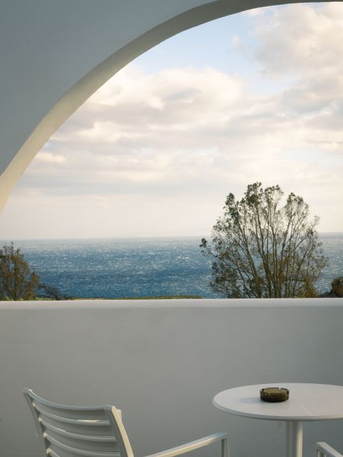 Free Peaceful ocean view from a white patio with archway and seating. Stock Photo