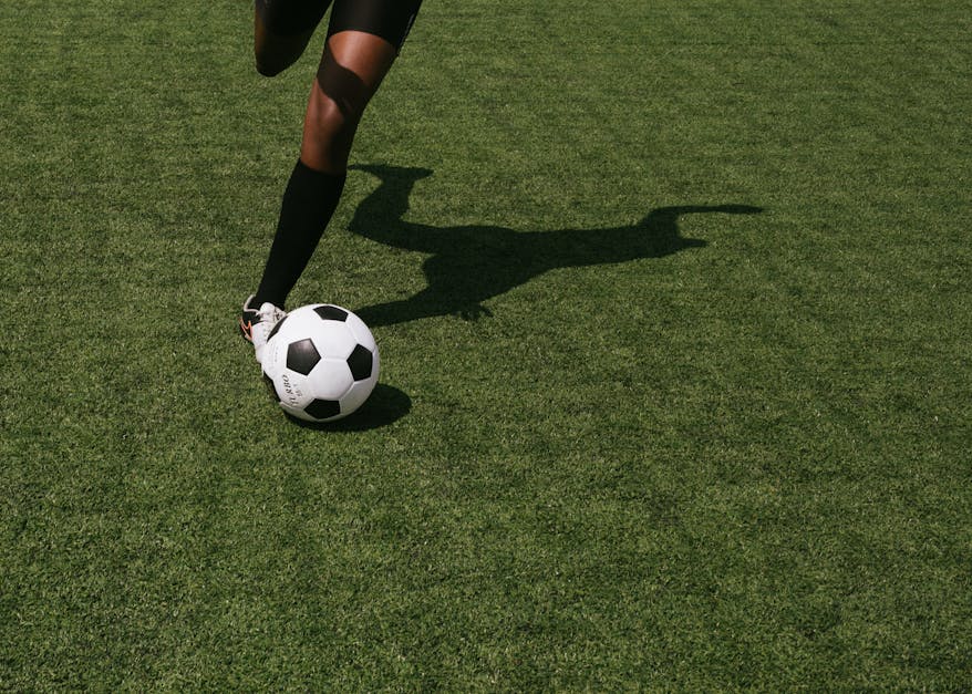 Anonymous soccer player on field during match · Free Stock Photo
