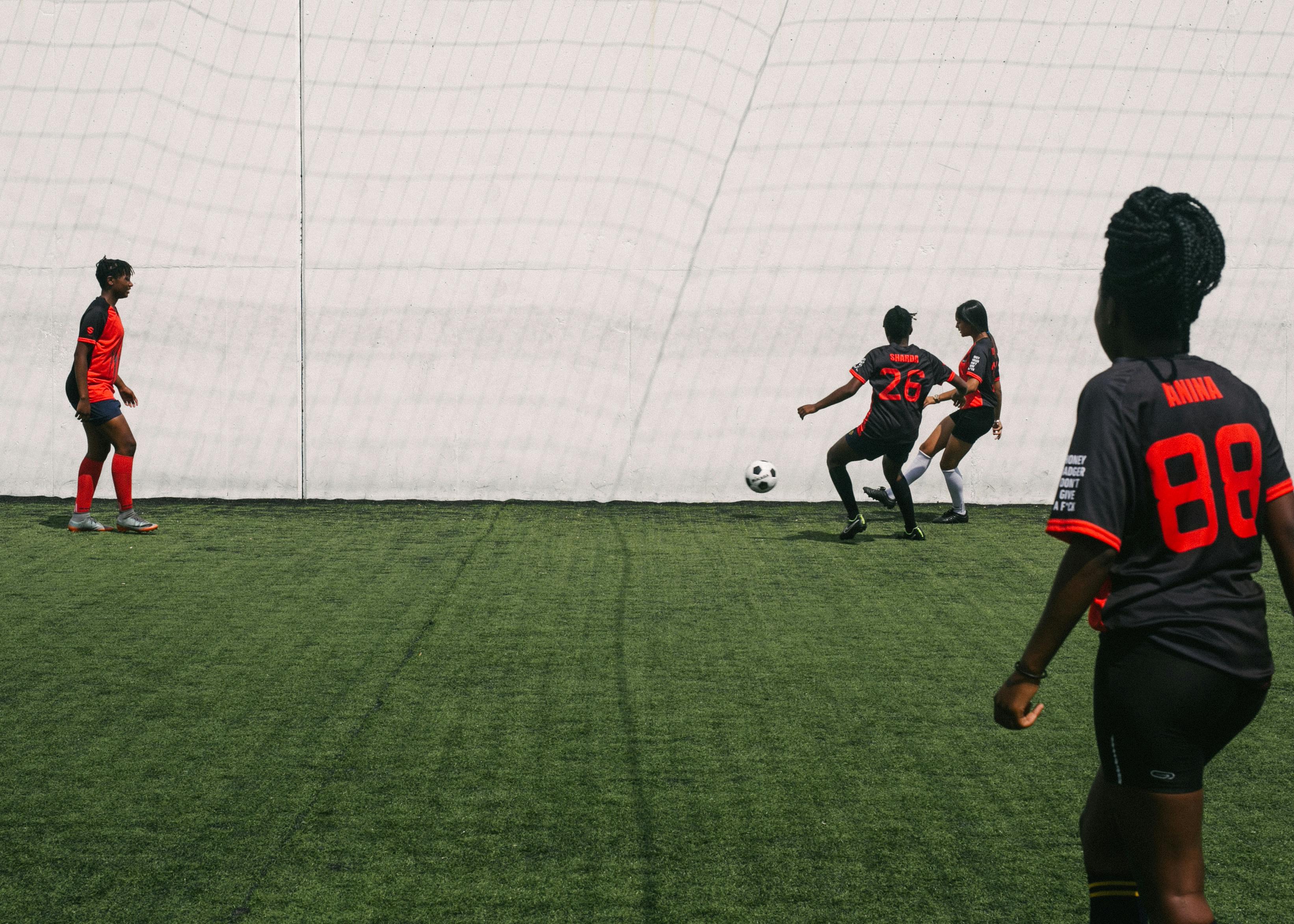 women playing in football on grass filed of stadium