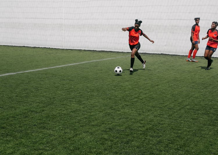 Woman Kicking Ball During Football Match