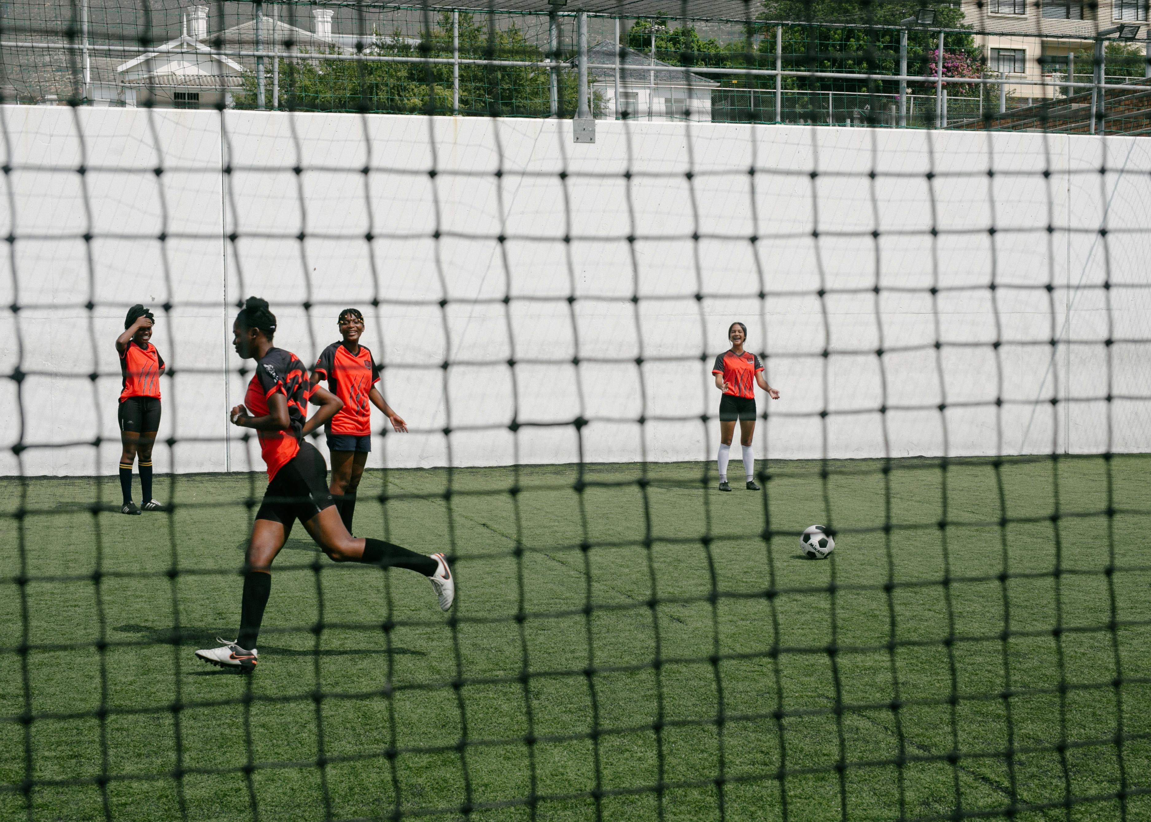 girls playing soccer on green grass field