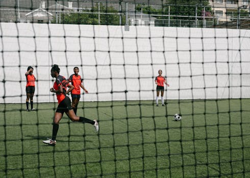 Group of female soccer players practicing on an outdoor field during the day.