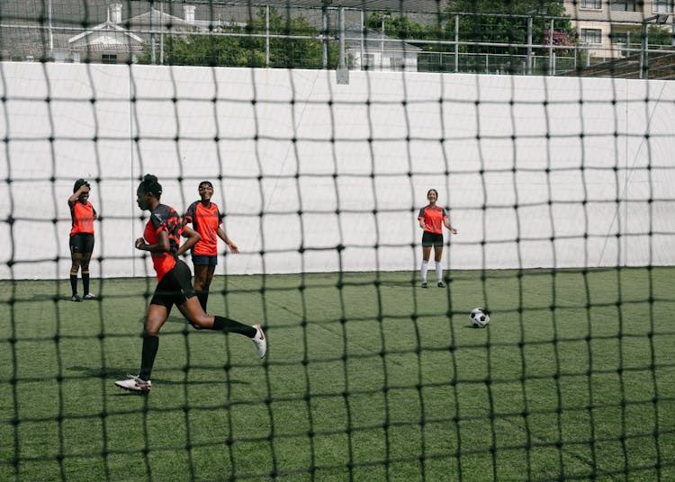 Girls Playing Soccer On Green Grass Field