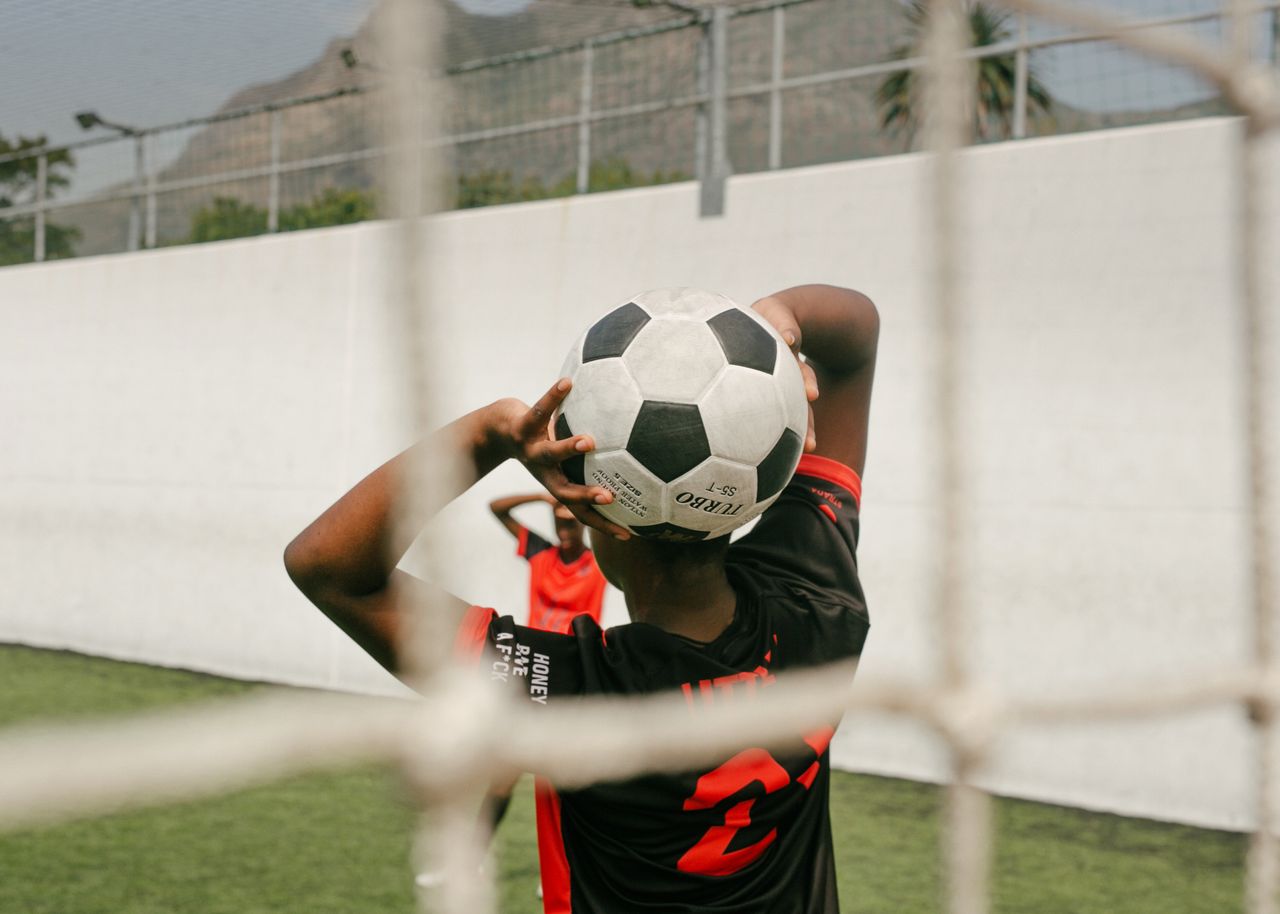 teen player preparing a throw in during a soccer match on an outdoor f