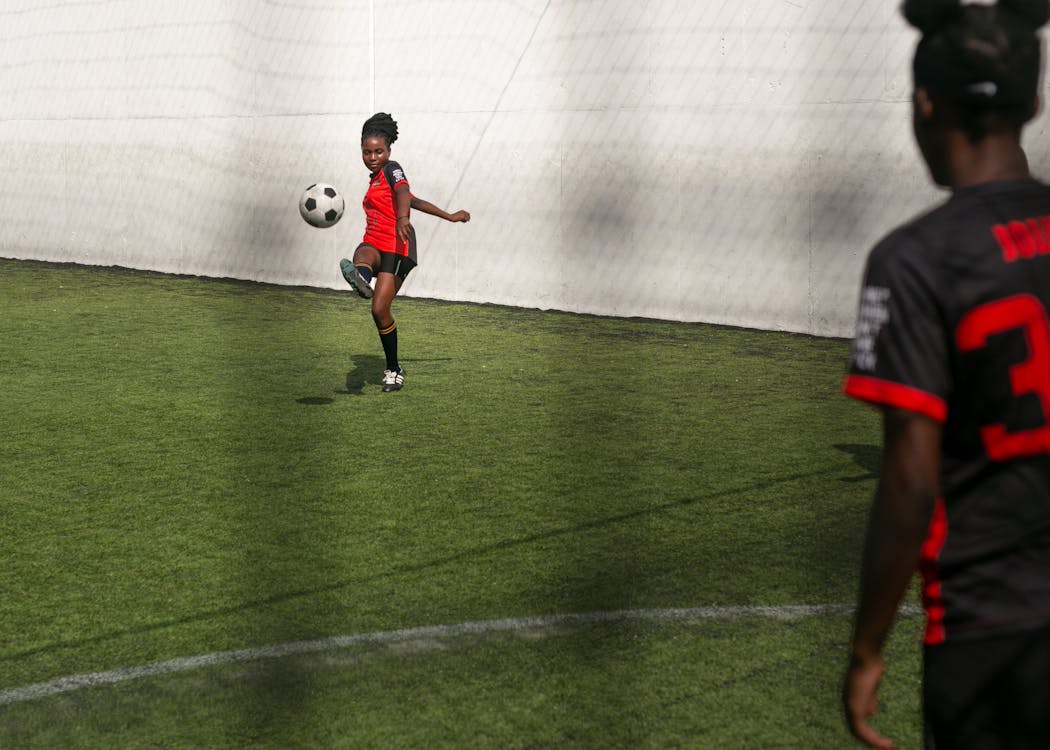 Girls Practicing Soccer In The Field might be considered opposite to her gender.