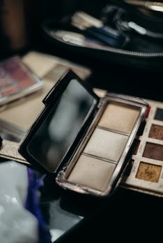 Open makeup palette with various shades and a mirror, ideal for beauty and cosmetics themes.