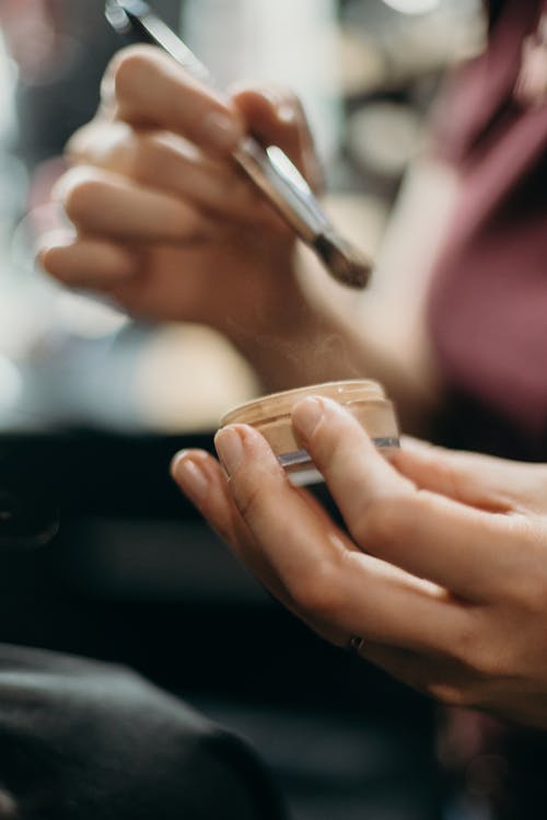 Person Holding Make Up Brush And Make Up