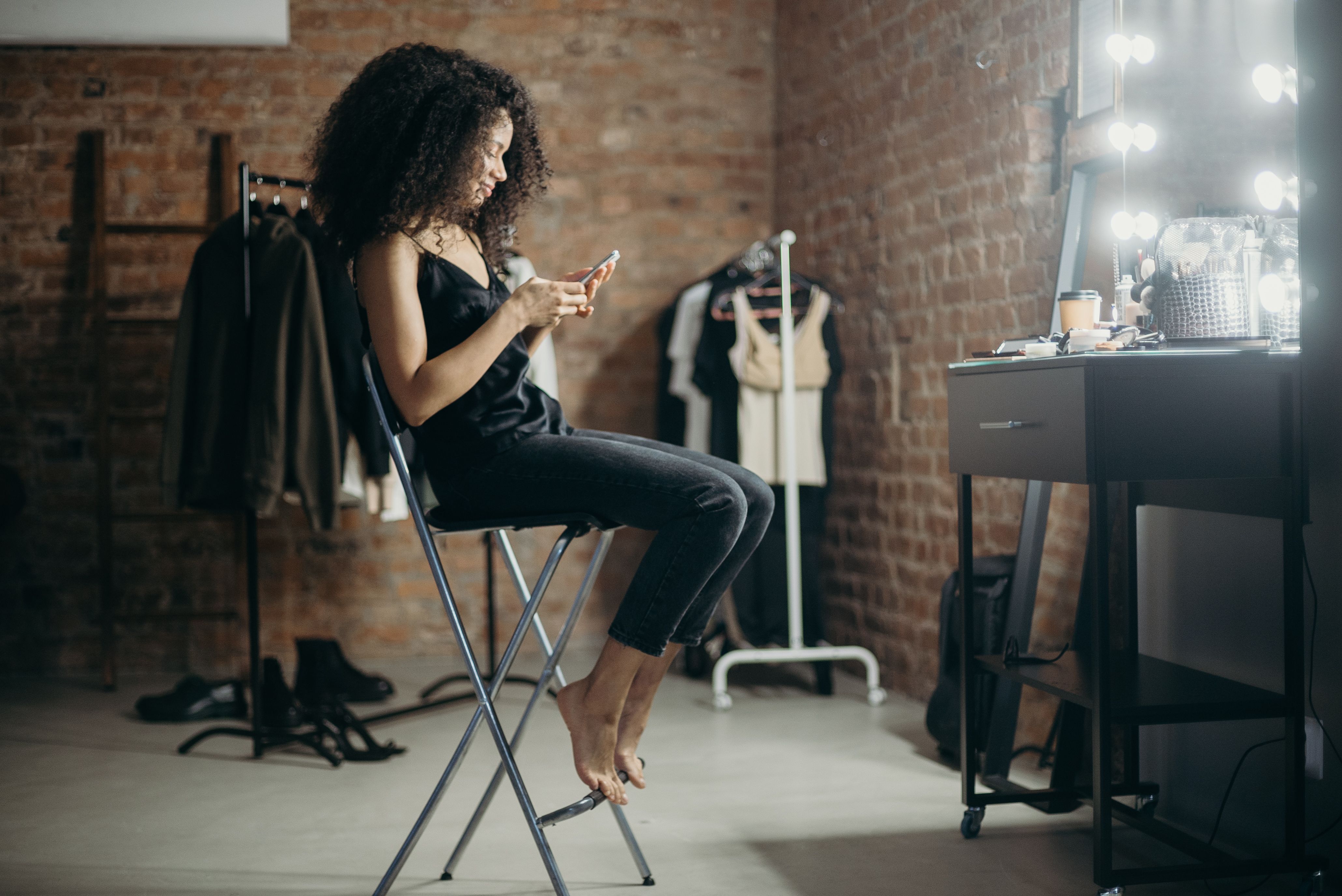 Woman In Black Tank Top And Black Pants Sitting On Chair · Free Stock Photo