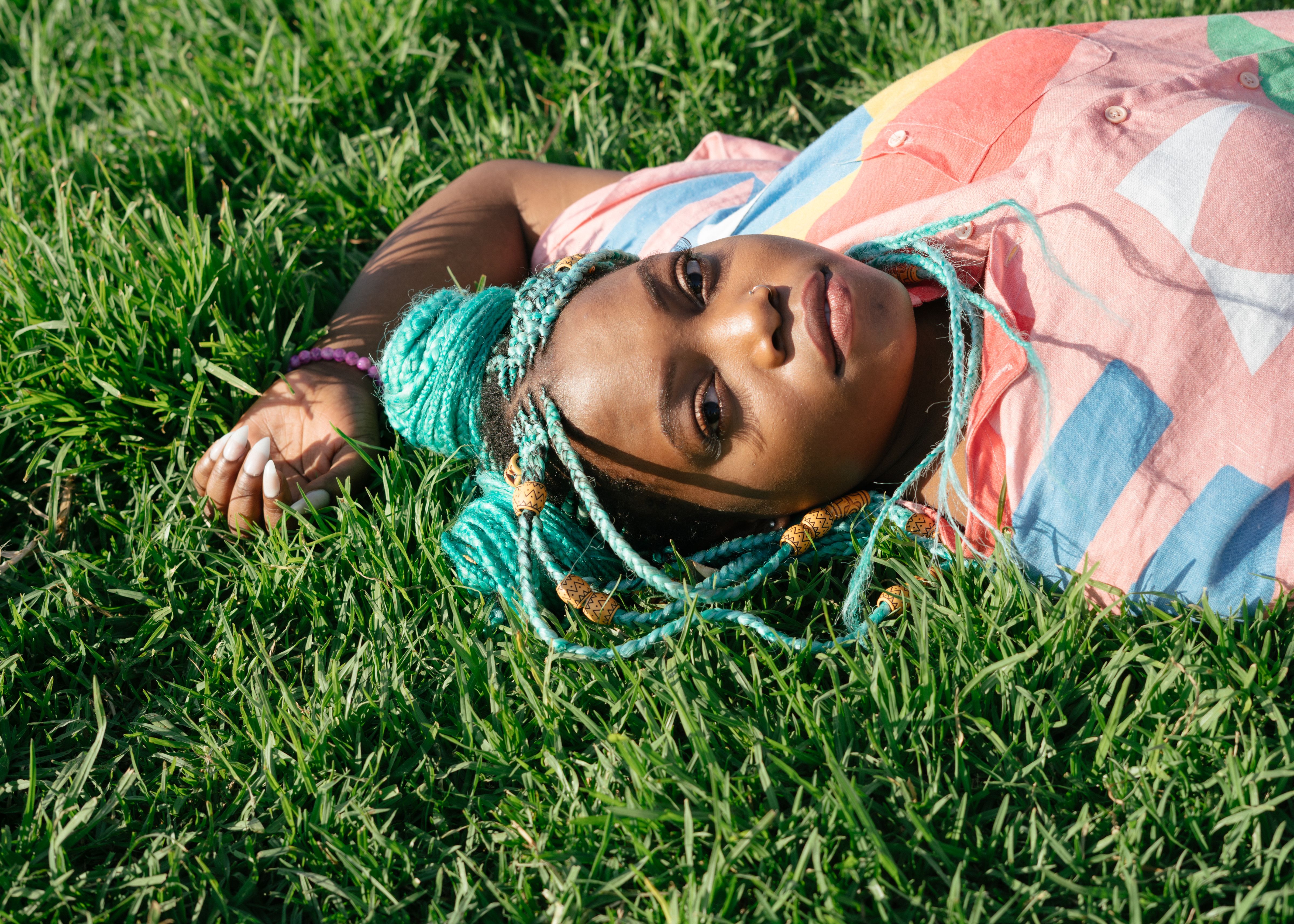 Woman In Long Sleeve Shirt Sitting On Green Grass Field · Free Stock Photo