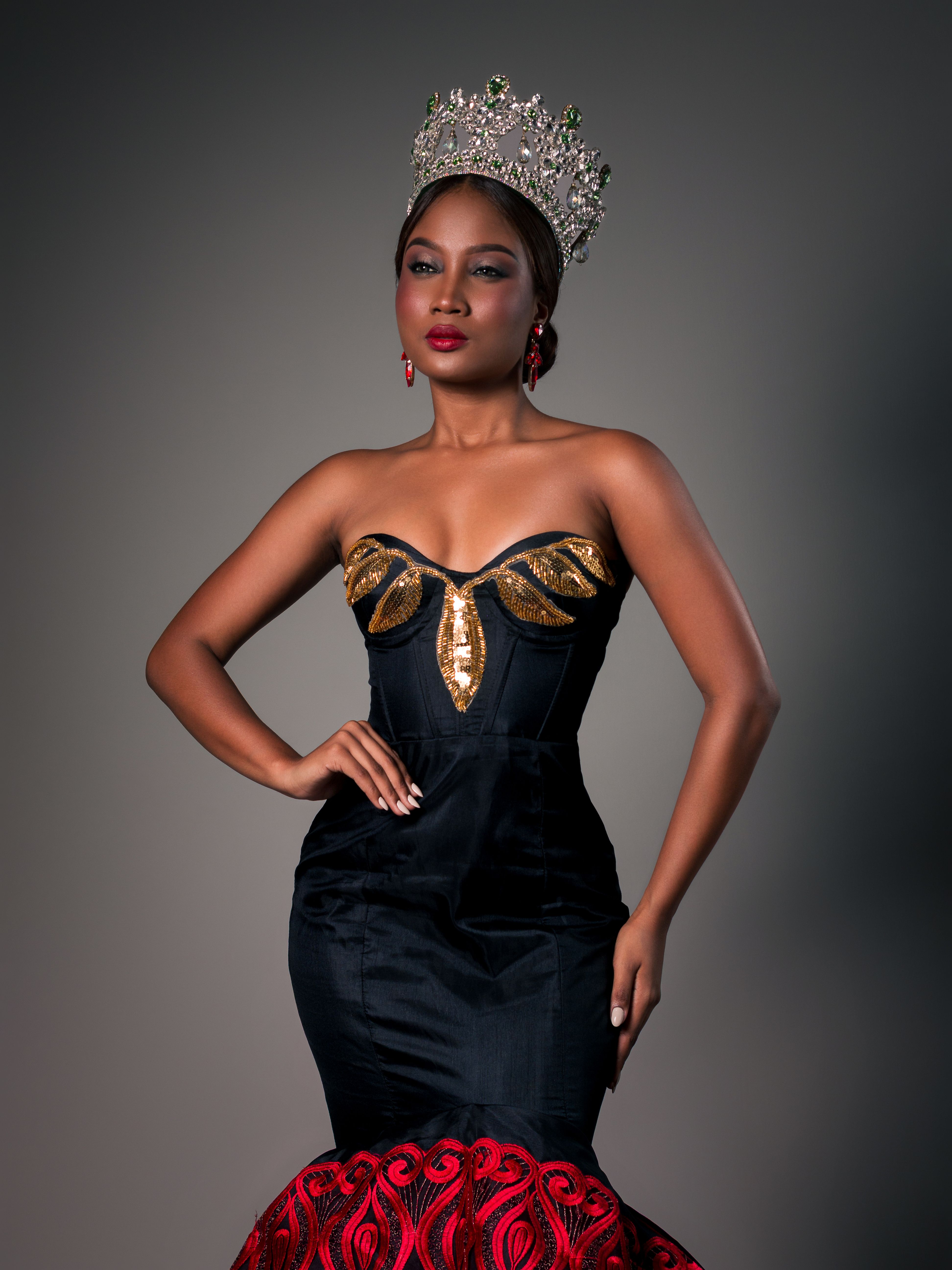 Portrait of a woman wearing an ornate crown and elegant evening gown.
