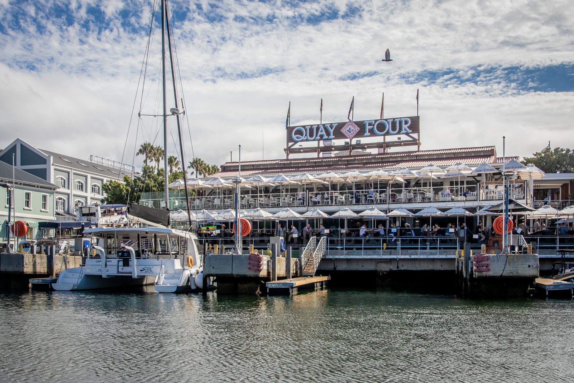Boats moored in front of the Quay Four restaurant and terraces at Cape Town's V&A Waterfront