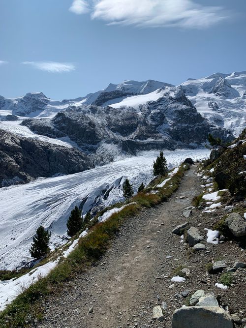 Free A scenic winter mountain path surrounded by snow-capped peaks, evoking a sense of tranquility. Stock Photo