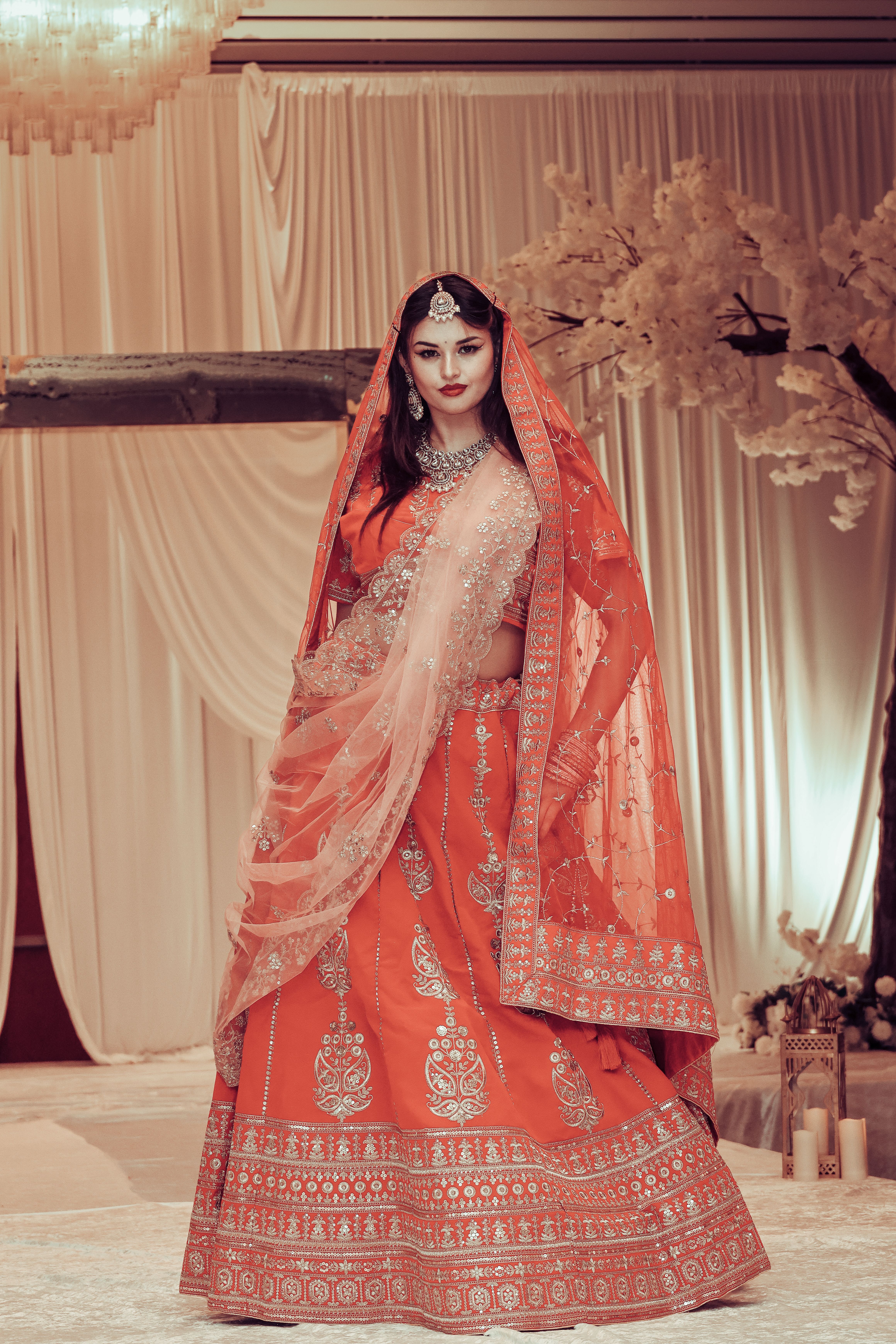 An opulent Indian luxury wedding venue featuring elegant table settings, decorative seating, and intricate floral arrangements.