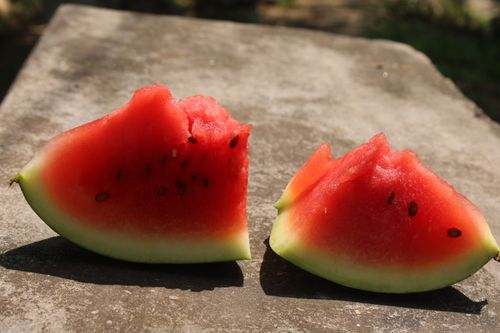 Free Close-up of juicy watermelon slices with seeds on a stone surface outdoors. Stock Photo