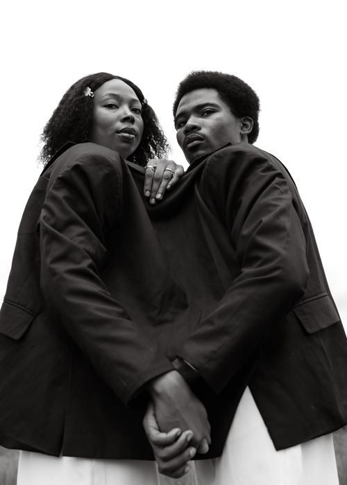 Free Stylish black and white portrait of two people in matching jackets, conveying unity and strength. Stock Photo