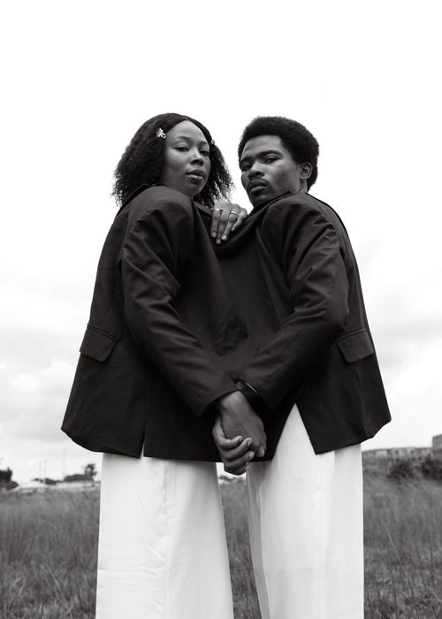 Free Striking black and white photo of two people in unity, wearing suits outdoors. Stock Photo