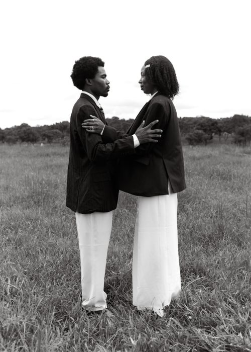 Free Elegant black and white portrait of a couple in a field embracing tenderly. Stock Photo