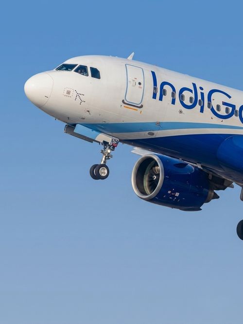 Free An IndiGo Airlines Airbus A320 captured mid-flight against a clear blue sky, showcasing aviation design. Stock Photo