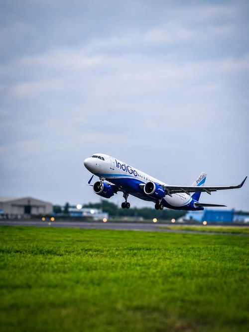 Free IndiGo airplane taking off from Coimbatore Airport, showcasing aviation dynamics. Stock Photo
