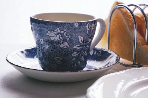 白色和蓝色花卉陶瓷茶杯在碟上
