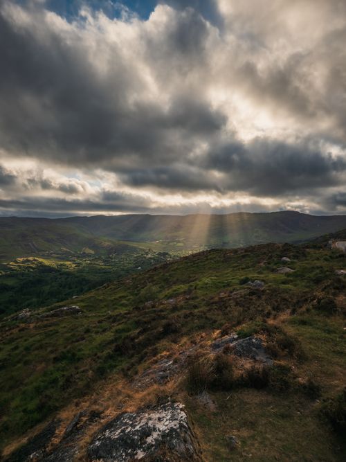 Free Captivating view of Irish hills with dramatic clouds and sun rays breaking through. Stock Photo