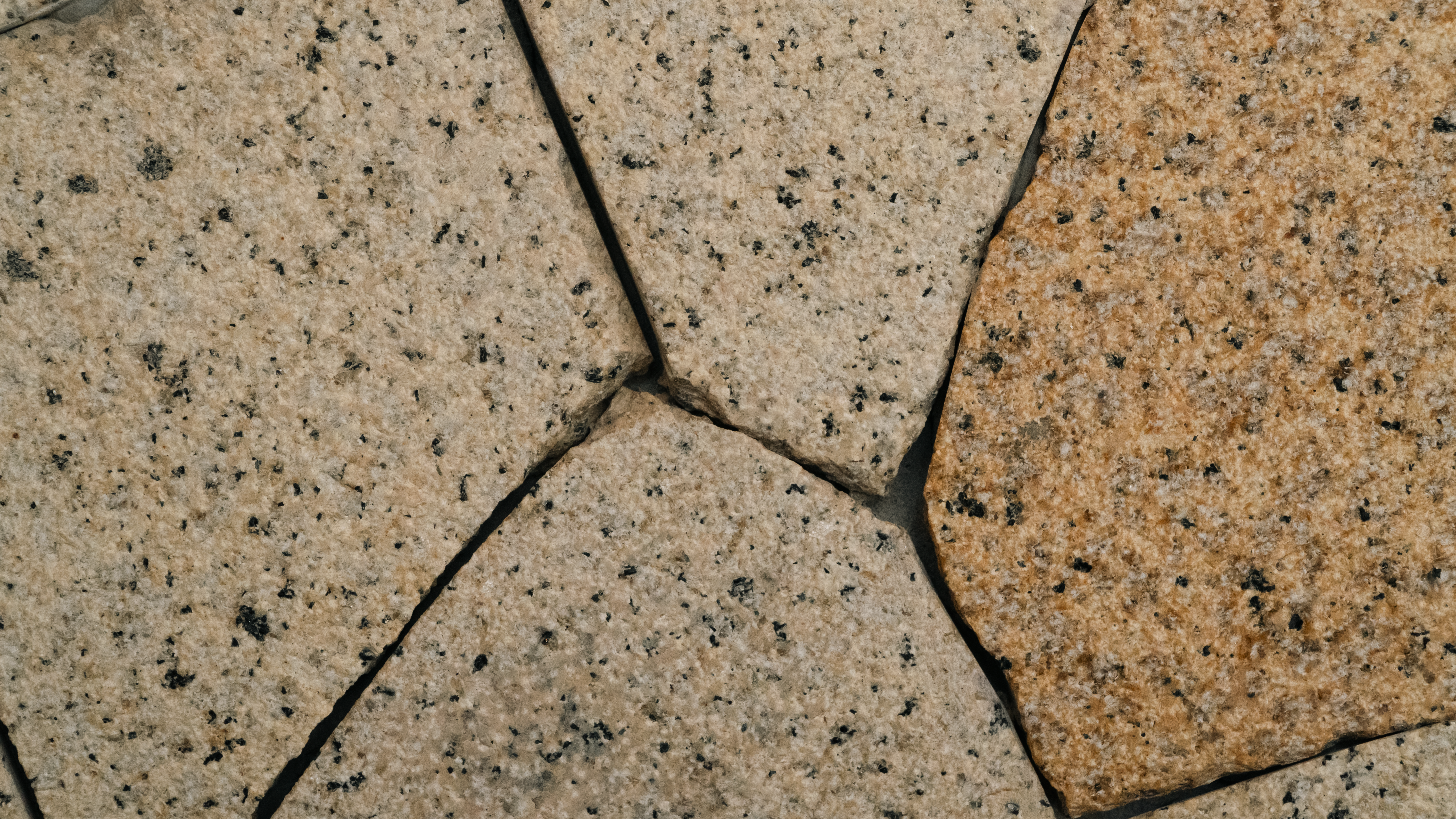 Detailed image of rough, textured stone tiles arranged in a pattern.