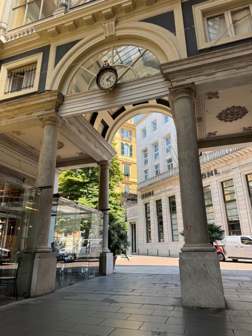 Free Classic archway with clock in Genoa, Italy, showcasing architectural elegance and historical charm. Stock Photo