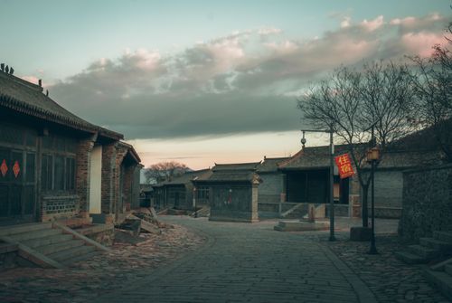Free Empty cobblestone street in a historic Chinese village at dusk with traditional architecture. Stock Photo