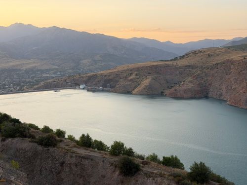 Free A breathtaking view of Charvak Reservoir at sunset, surrounded by mountains in Uzbekistan. Stock Photo