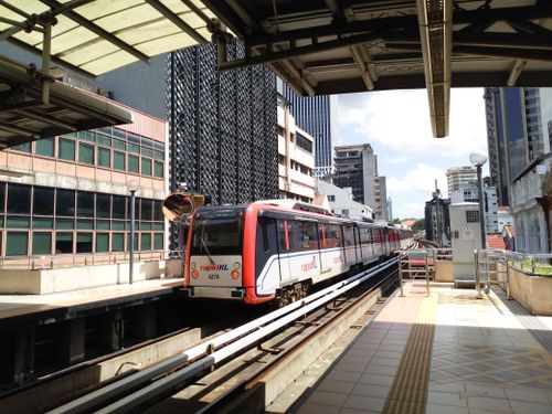 Free Rapid KL train arriving at a busy Kuala Lumpur station on a sunny day. Stock Photo