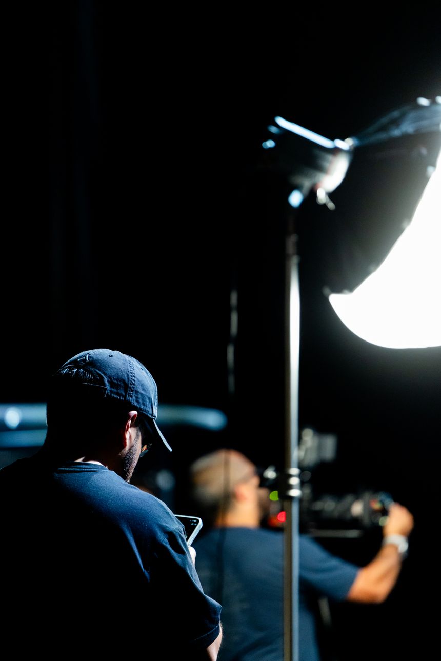 Film crew setting up lighting on a sound stage, by Caleb Oquendo on Pexels