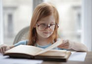 Girl Reading A Book With Eyeglasses