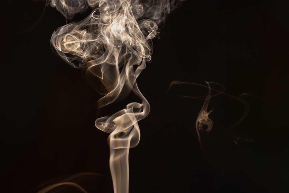 Fotomural Imagen abstracta de remolinos de humo capturados con maestría sobre un fondo oscuro, que muestra intrincados patrones.
