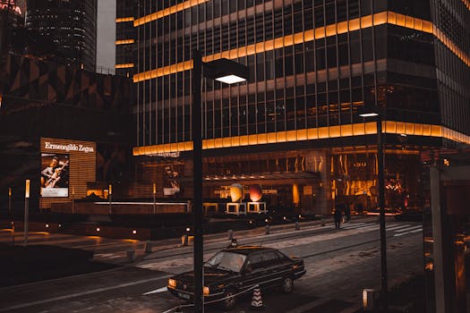 夜晚的城市街道繁忙，明亮的摩天大楼与停放的车辆林立