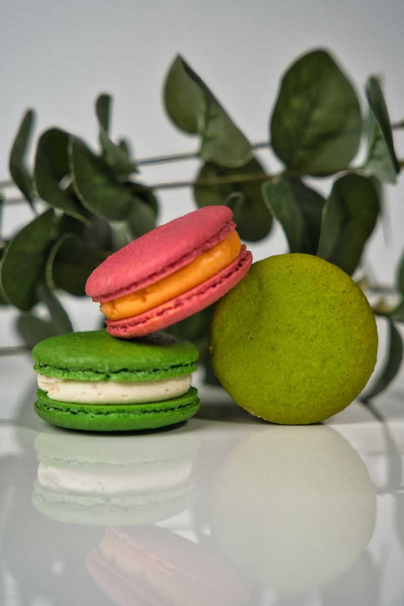 Macarons franceses coloridos sobre fundo com folhagem