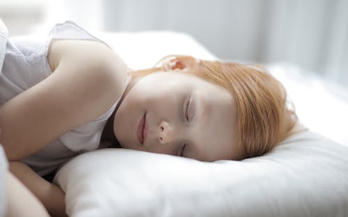 Free Happy cute girl sleeping in bed peacefully Stock Photo