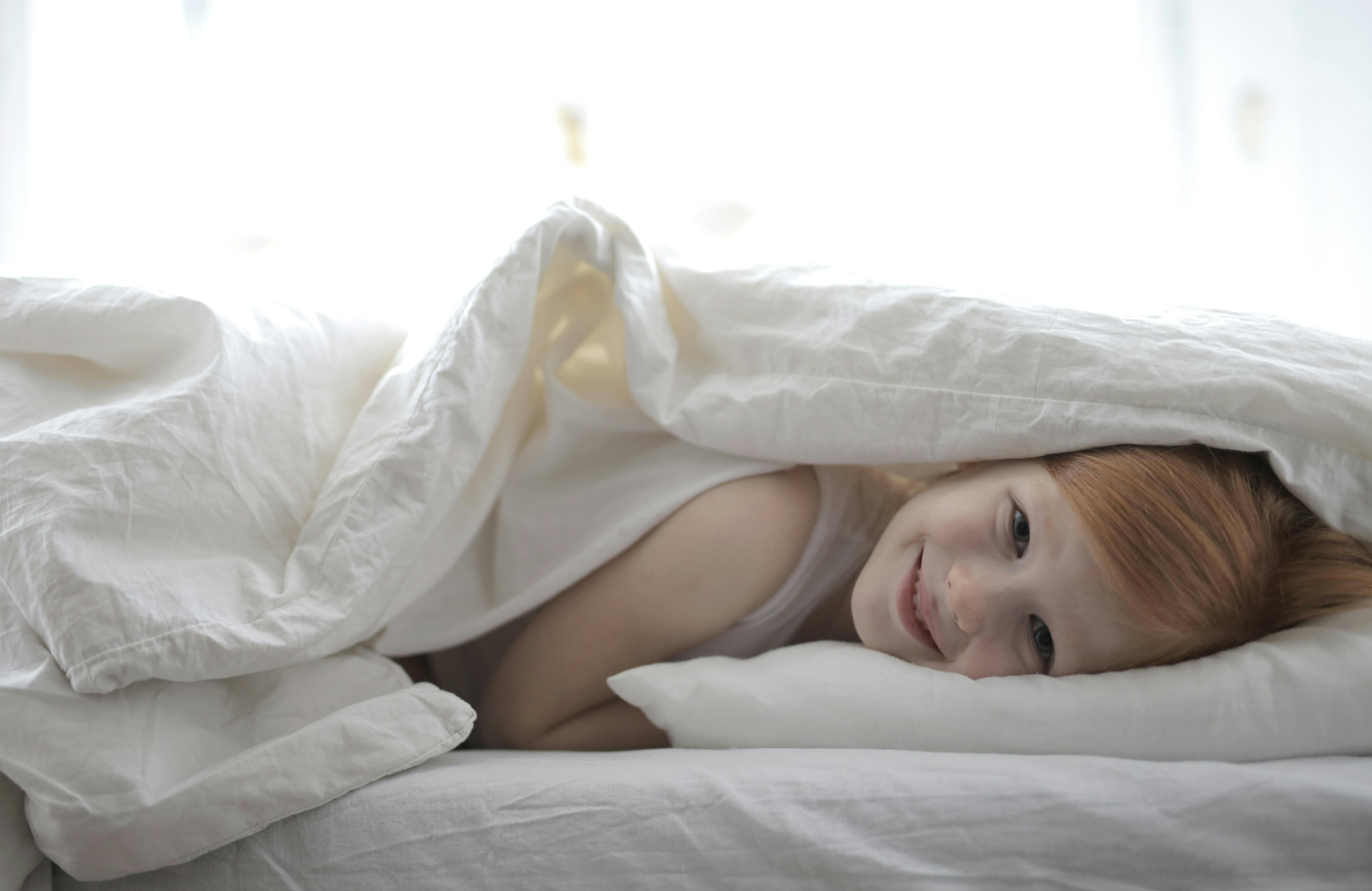 Girl Lying On Bed Covered With White Blanket · Free Stock Photo