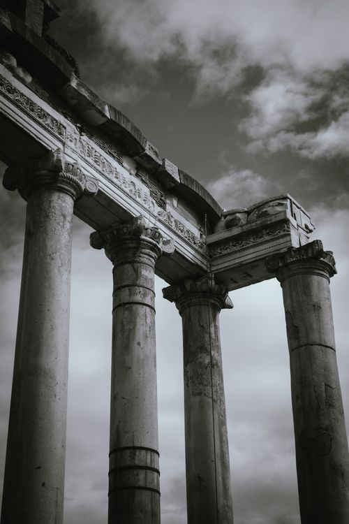Free Striking black and white photo of ancient Roman columns under a moody sky. Stock Photo