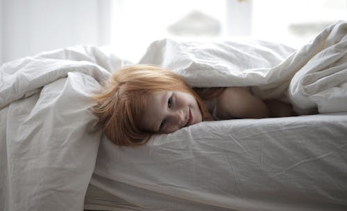 Free Girl Lying In Bed With White Linen And Blanket Stock Photo