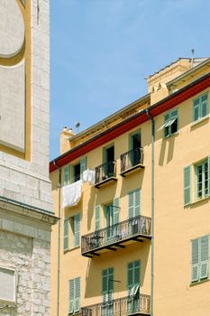 A sunlit view of traditional Mediterranean apartments in Nice, France, showcasing vibrant architecture.