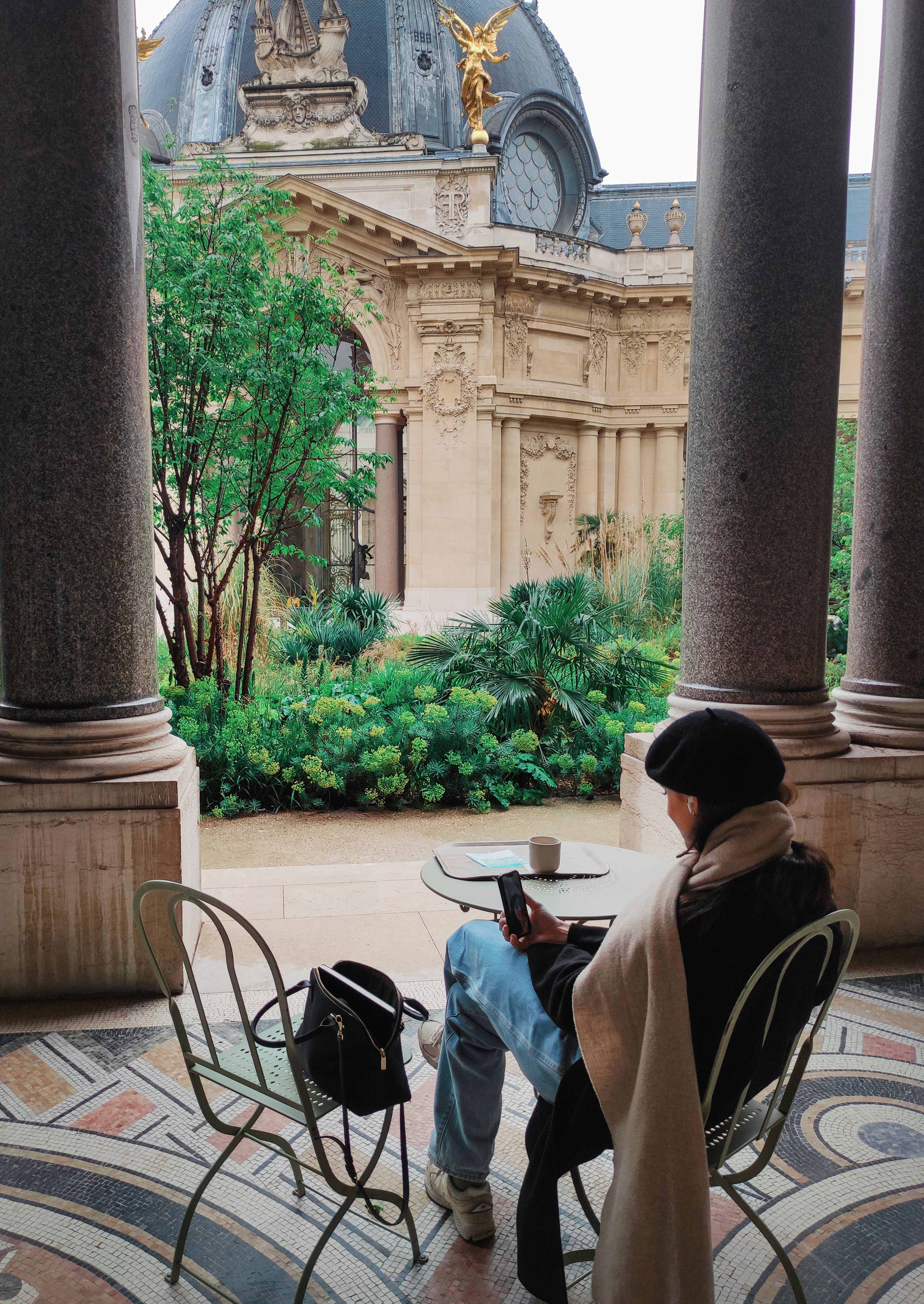 A peaceful moment in a Parisian cafe overlooking the ornate architecture of Petit Palais.