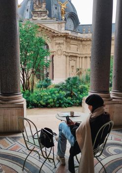 A peaceful moment in a Parisian cafe overlooking the ornate architecture of Petit Palais.