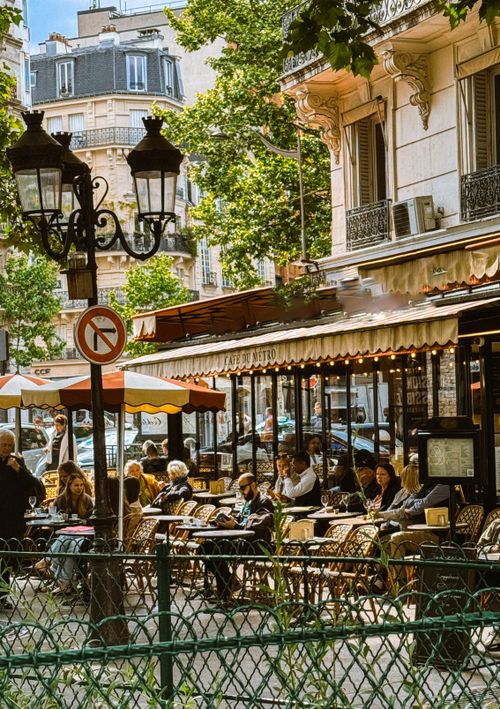 Free Bustling outdoor cafe in Paris with people enjoying a sunny day, France. Stock Photo
