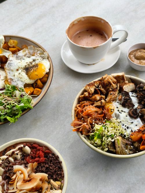 Free A selection of diverse brunch bowls and a hot chocolate on a marble table. Stock Photo