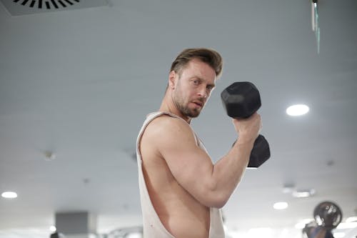 Man in White Tank Top Holding Black Dumbbell