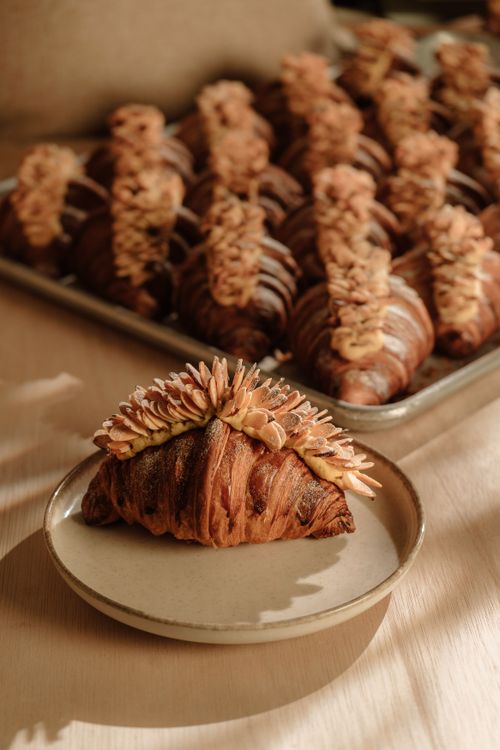 Free Delicious artisanal croissants topped with almonds on a rustic plate. Stock Photo