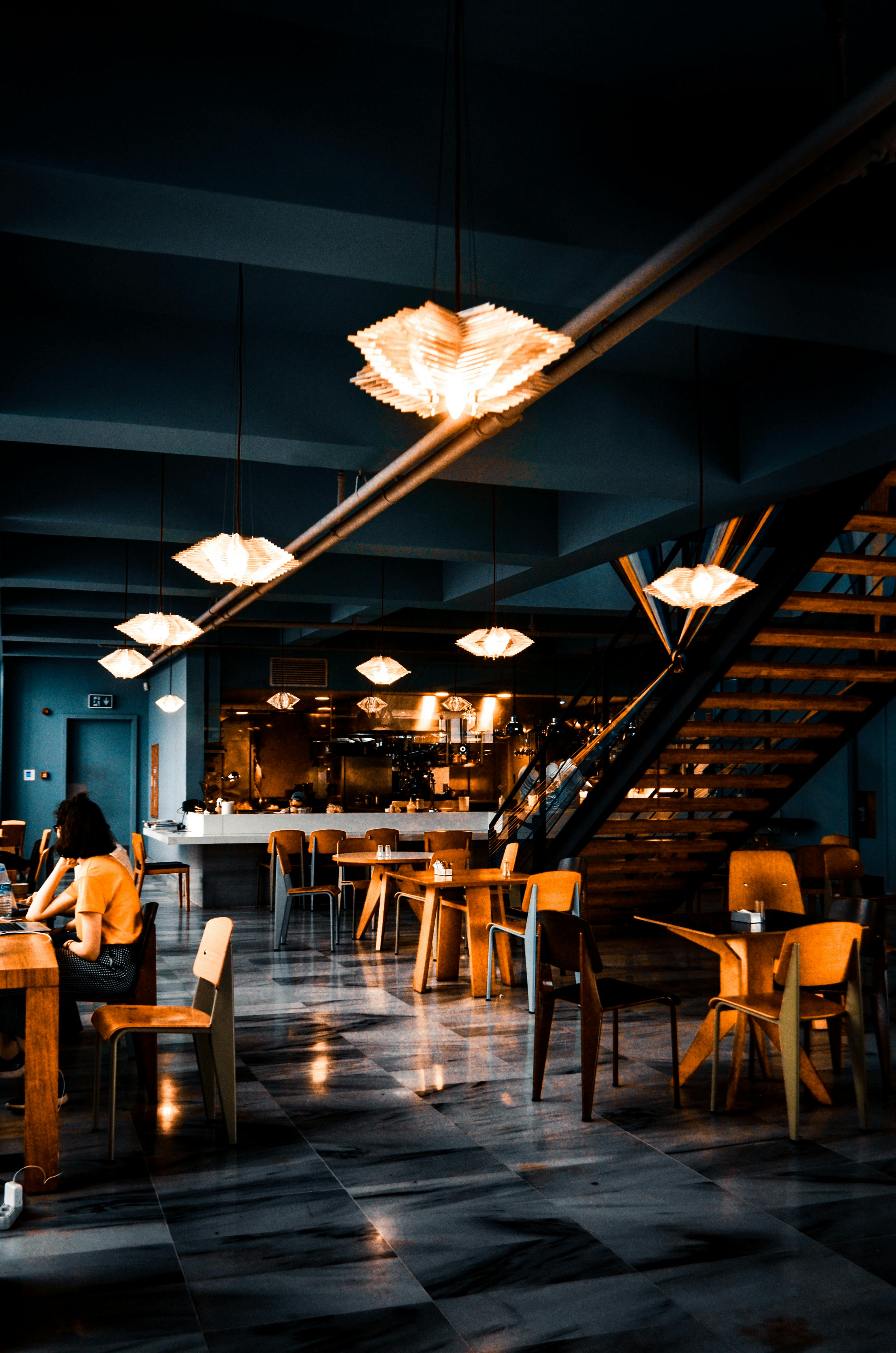 trendy interior of cafe with creative lamps and wooden furniture