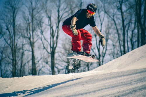 Free Man Riding on Snowboard In Mid Air Jump Stock Photo